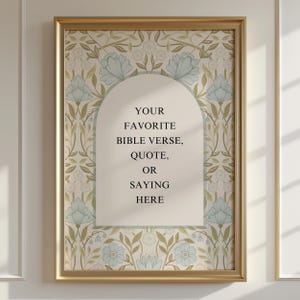 Op de afbeelding: Een rechthoekige wandkunstprint in een gouden lijst met een herhalend bloemenpatroon van lichtblauwe bloemen en groene bladeren. Een centrale crèmekleurige boog bevat de zwarte tekst: YOUR FAVORITE BIBLE VERSE, QUOTE, OR SAYING HERE.