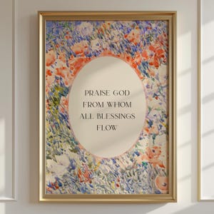 May include: A framed wall art print featuring a watercolor-style floral background in shades of blue, orange, and cream. A central oval contains the black text: PRAISE GOD FROM WHOM ALL BLESSINGS FLOW. The artwork is enclosed in a thin gold frame.