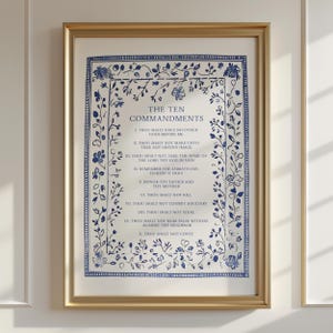 Puede incluir: Impresión enmarcada de los Diez Mandamientos. El texto azul está rodeado por un borde floral sobre un fondo crema. El marco es dorado.
