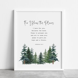 May include: A framed wall art print featuring the text For I Know the Plans I have for you, declares the Lord. Plans to prosper you and not to harm you; plans to give you hope and a future. JEREMIAH 29:11 above a watercolour forest of pine trees.