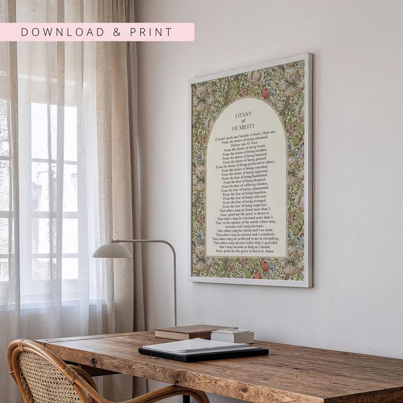 May include: A rectangular wall art print featuring the Litany of Humility prayer text centred within an arched cream-coloured panel. The border displays a dense, colourful floral and botanical pattern with green, red, and white elements.