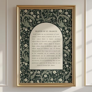 May include: A framed print featuring the "Prayer of St. Francis" text. The print has a gold frame and a dark green floral patterned background. The text is in a cream-colored arch shape in the center of the print.