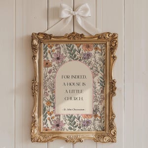 Può includere: Una stampa floreale incorniciata con una cornice dorata ornata e un fiocco bianco. La stampa presenta un arco color crema con la citazione "FOR INDEED, A HOUSE IS A LITTLE CHURCH." Motivi floreali in rosa, arancione e verde circondano il testo.