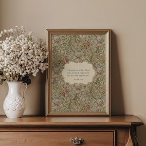 May include: A framed print with a floral pattern in shades of green, red, and blue. The frame is gold-colored. The print features the text "Therefore what God has joined together, let no one separate. MARK 10:9."