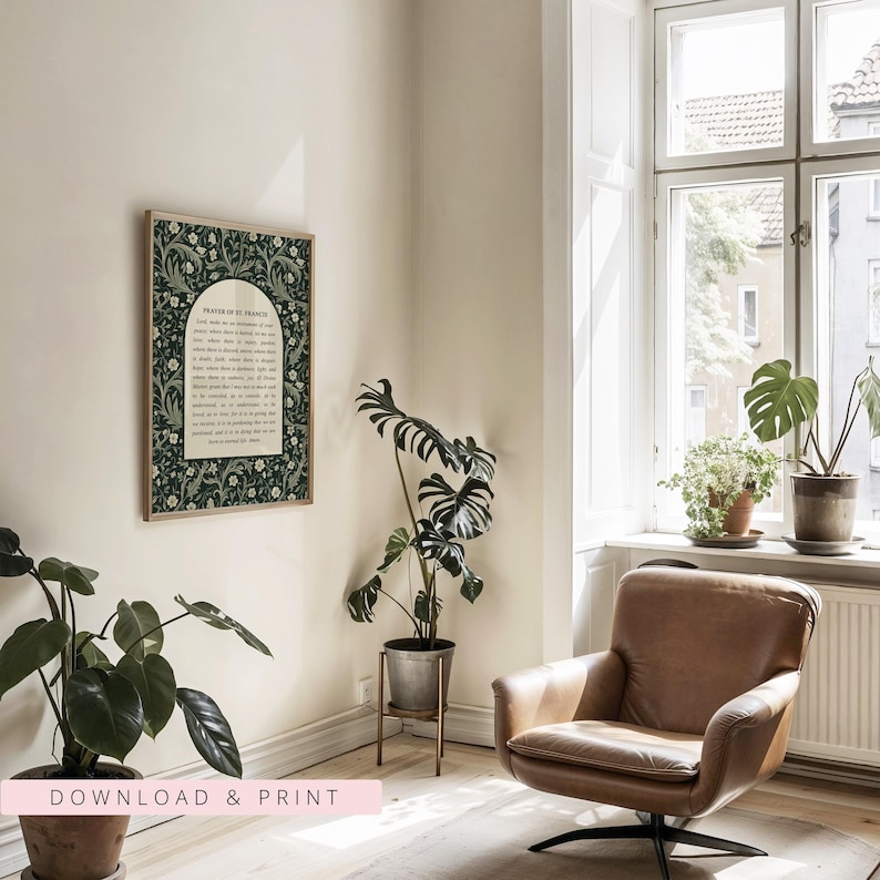May include: A framed print of the Prayer of St. Francis with a dark green floral border. The print is displayed in a room with a leather armchair, potted plants, and a window. The text "DOWNLOAD & PRINT" is at the bottom.