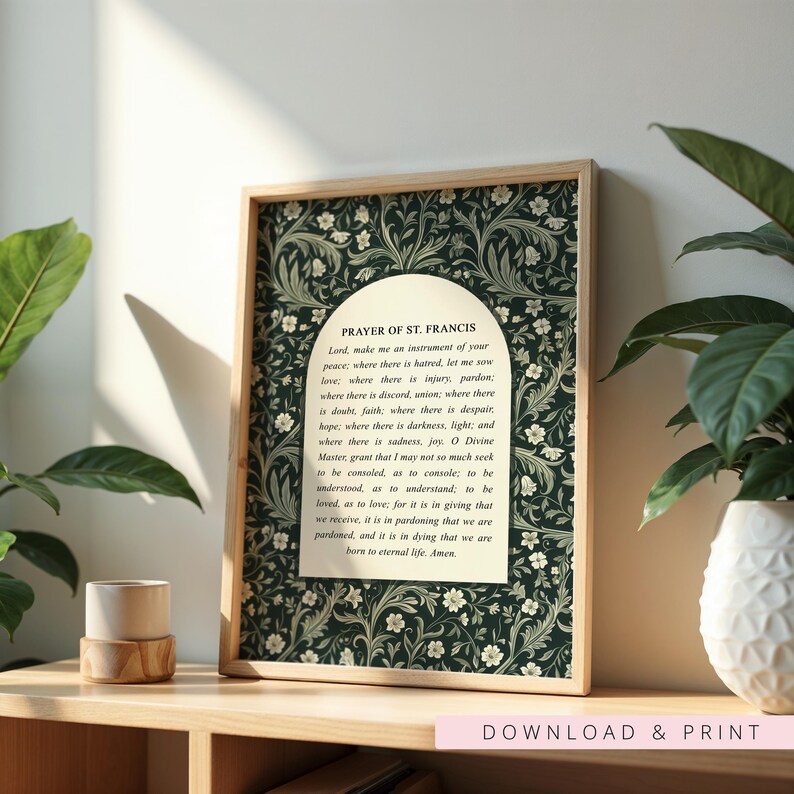 May include: A framed print featuring the "Prayer of St. Francis" text. The print has a dark green floral pattern background and a light wood frame. The text is in a white arched shape. The words "DOWNLOAD & PRINT" are at the bottom.