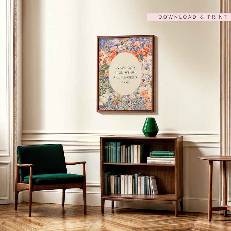 May include: A framed wall art print featuring a floral background with an oval center containing the text 'PRAISE GOD FROM WHOM ALL BLESSINGS FLOW'. The artwork is displayed above a wooden bookshelf filled with books and a green vase.