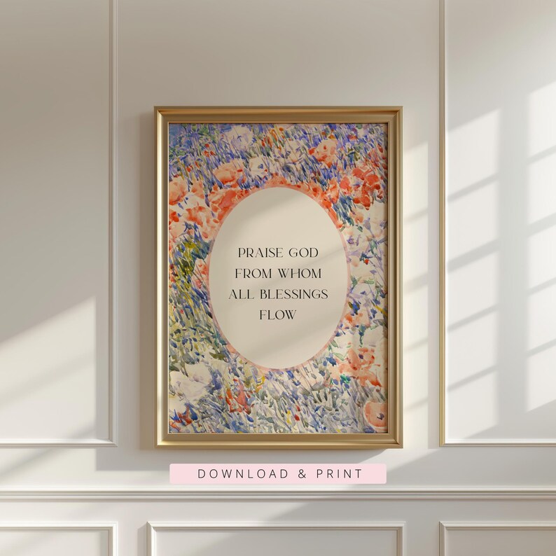 May include: A framed wall art print featuring a watercolor-style floral meadow in shades of orange, blue, and green. A central cream-colored oval contains the black text: PRAISE GOD FROM WHOM ALL BLESSINGS FLOW. The frame is a metallic gold finish.