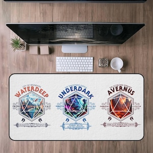 May include: A white rectangular desk mat featuring three geometric designs with text. The designs are for Waterdeep, Underdark, and Avernus. The mat is on a wooden desk with a computer monitor, keyboard, and other office supplies.