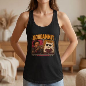 以下が含まれることがあります： GODDAMMITおよびTHE PRINCESS DISAPPROVESのテキストがプリントされた黒のレーサーバックタンクトップ。指をさす男性と、金の王冠とサングラスを身につけ、赤いサクランボのボウルの後ろに座る白い猫のグラフィックデザインが施されています。