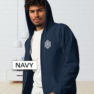May include: Navy blue zip-up hoodie with a white geometric design on the chest. The hoodie has a drawstring hood and a full-length zipper. The word "NAVY" is displayed on a white rectangle.