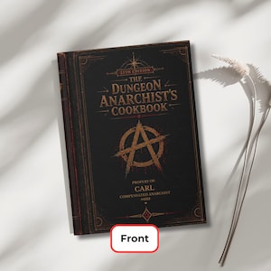 May include: A black hardback book titled The Dungeon Anarchist's Cookbook, 25th Edition. The cover features gold and red decorative borders, a large letter A inside a circle, and text reading Property of Carl, Compensated Anarchist #4122.