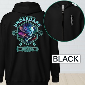 May include: Black zip-up hoodie with a graphic on the back featuring the text "UNDERDARK" and "JOURNEY BELOW, FACE THE UNKNOWN". The graphic is a colorful fantasy scene. The hoodie also has a small sword design.
