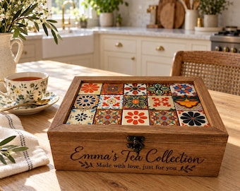 May include: A rectangular wooden tea box with a hinged lid featuring a grid of fifteen colorful floral and geometric patterned tiles. The front of the box is engraved with the text Emma's Tea Collection Made with love, just for you.