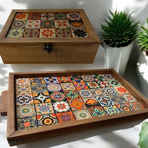 May include: Two wooden trays with colorful tile designs. The top tray is a box with a hinged lid. Both trays have a brown wood frame.