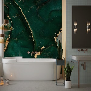May include: A modern bathroom with a freestanding bathtub and a sink with a green and gold marble patterned wall. The bathroom has a large mirror and two wall sconces.