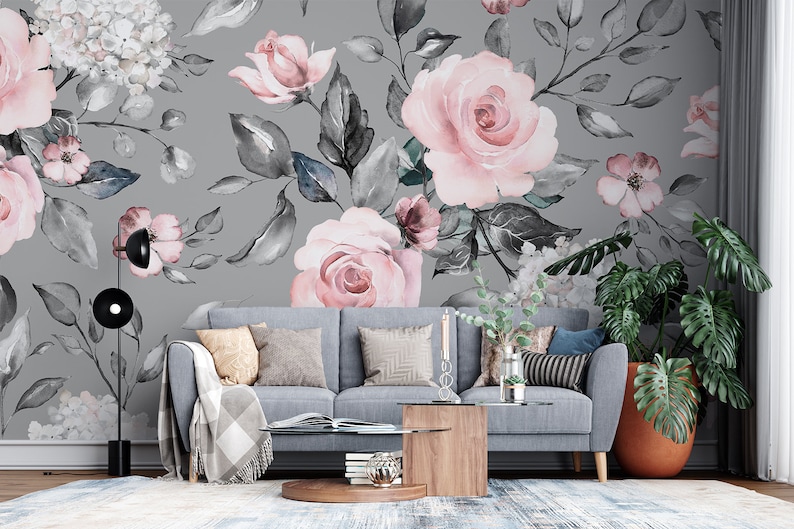 May include: A gray living room with a gray couch and a floral wallpaper featuring pink roses and gray leaves. A potted plant with large green leaves is in the corner of the room.