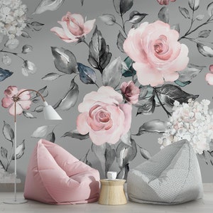 May include: A gray and pink floral wallpaper with a watercolor design featuring roses, hydrangeas, and leaves. Two beanbag chairs, one pink and one gray, are in the foreground.