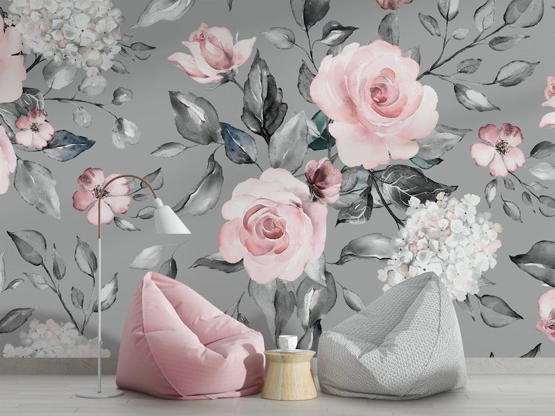 May include: A gray and pink floral wallpaper with a watercolor design featuring roses, hydrangeas, and leaves. Two beanbag chairs, one pink and one gray, are in the foreground.