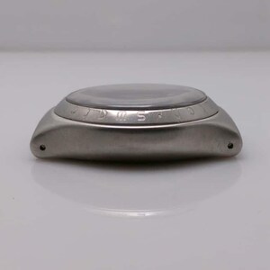 May include: A stainless steel wristwatch with a dark face and a curved, polished metal case. The watch has a circular face with a clear crystal and a bezel with engraved markings. The watch is shown from a side profile.