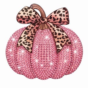 May include: A pumpkin-shaped ornament covered in small, sparkling pink rhinestones. The pumpkin features a brown stem topped with a large, decorative bow featuring a tan and black leopard print pattern. The surface reflects light with a glittery effect.
