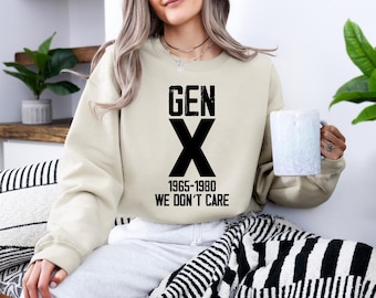 May include: A beige sweatshirt with black text that reads "GEN X 1965-1980 WE DON'T CARE".