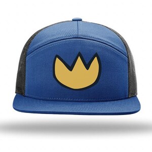 May include: A blue five-panel snapback cap featuring a black mesh back and a yellow crown-shaped graphic on the front panel. The hat has a flat brim and a structured front, with a solid blue fabric crown and a dark mesh rear section for ventilation.