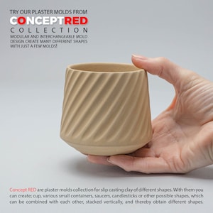 Puede incluir: Una mano sostiene un molde de yeso beige para fundir arcilla. El molde tiene forma de taza con un diseño en espiral. El texto "Concept RED" es visible en la imagen.