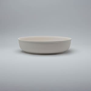 Pode incluir: Uma tigela de cer&acirc;mica branca suja. A tigela tem uma forma rasa e arredondada com um acabamento liso e fosco. A tigela &eacute; adequada para servir alimentos ou como pe&ccedil;a decorativa. A cor neutra da tigela torna-a vers&aacute;til.