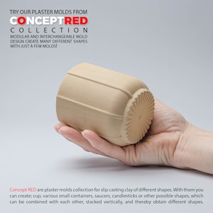 以下が含まれることがあります： 手で持たれた、粘土を流し込むためのベージュ色の石膏型。型は、垂直線と装飾的な円形の基部を備えた円筒形をしています。画像には「CONCEPT RED COLLECTION」というテキストがあり、型のモジュール設計について説明しています。
