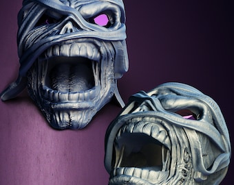 May include: Two gray, detailed, 3D printed sculptures of a screaming face with a bandage over the eyes. The sculptures are made to look like a monster or a creature.