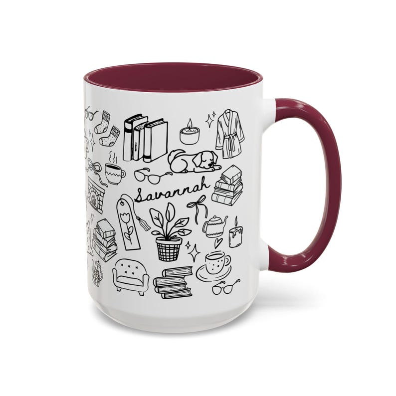 May include: White ceramic mug with a claret interior and handle. The mug features black line art of books, a dog, a fireplace, and the word "Savannah".