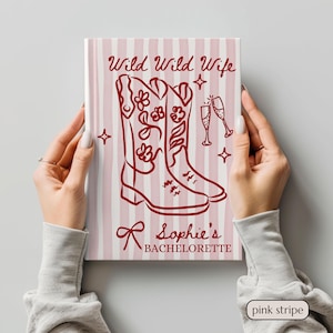Könnte beinhalten: Eine rosa-weiß gestreifte Leinwand mit dem Text "Wild Wild Wife" und "Sophie's Bachelorette". Die Leinwand zeigt eine rote Illustration von Cowboy-Stiefeln, Sektgläsern und Sternen. Die Leinwand wird von zwei Händen gehalten.