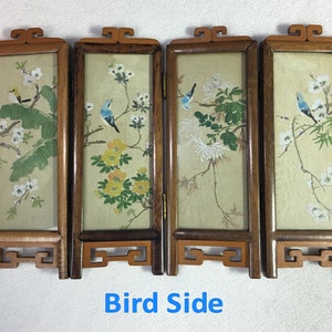 May include: A four-panel wooden screen with a traditional Chinese design. Each panel features a delicate floral motif with birds in shades of blue and yellow. The screen is in good condition and has a beautiful patina.