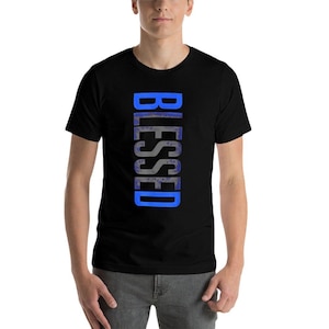 May include: Black t-shirt with the word "BLESSED" printed vertically in blue. The text has a textured, watercolor-like appearance. The shirt is short-sleeved and appears to be made of a soft material.