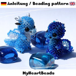 Pode incluir: Duas figuras de dragões de contas em tons de azul e branco, com olhos pretos, são exibidas ao lado de várias pedras de vidro azuis. O texto "Anleitung / Beading pattern" está no topo. A marca "MyHeartBeads" está na parte inferior.