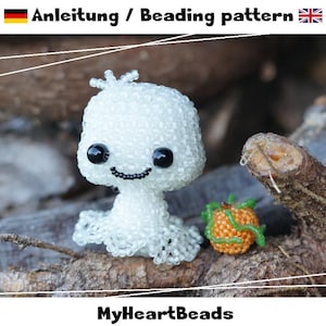 Pode incluir: Uma figura de fantasma feita de missangas brancas com olhos e boca de missangas pretas, acompanhada por uma pequena abóbora de missangas cor de laranja com gavinhas de missangas verdes. O texto diz Anleitung / Beading pattern e MyHeartBeads.
