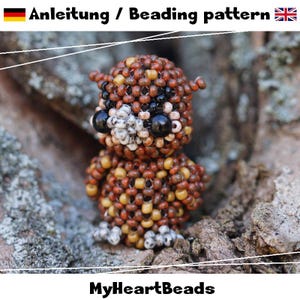 May include: A handcrafted beaded owl, featuring brown, tan, black, and white beads. The owl has large black eyes and a white chest. The text "Anleitung / Beading pattern" is at the top, and "MyHeartBeads" is at the bottom.