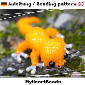 May include: A beaded orange gecko figurine with black eyes and white feet. The gecko is made of small, round beads. The text "Anleitung / Beading pattern" is at the top, and "MyHeartBeads" is at the bottom.