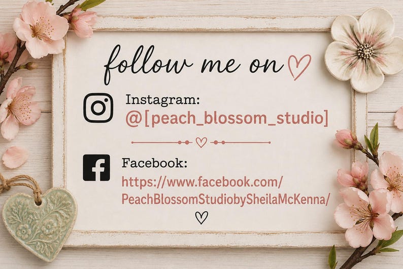 Pu&ograve; includere: Un cartello rettangolare con sfondo bianco e cornice in legno, decorato con fiori di ciliegio rosa e un ornamento a forma di cuore verde. Il testo recita: follow me on, Instagram: @[peach_blossom_studio] e Facebook: https://www.facebook.com/PeachBlossomStudiobySheilaMcKenna/.