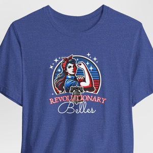 May include: A blue t-shirt with a graphic of a woman with red, white, and blue colors, with the text "Revolutionary Belles" in white.