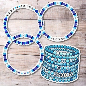 May include: A set of blue and white friendship bracelets with the words "Keep Going", "Love", and "Unity".