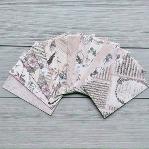 May include: A set of ten decorative paper sheets with vintage floral and musical note designs. The sheets are beige with black and grey accents.