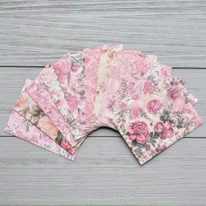 May include: A fan of pink and cream floral patterned paper squares. The paper has a vintage look and feel.