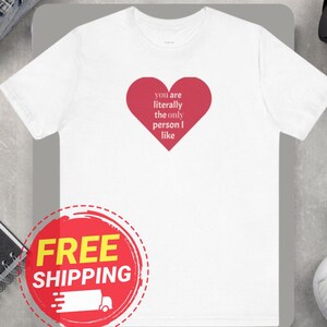 May include: White t-shirt with a red heart graphic that says "you are literally the only person I like".