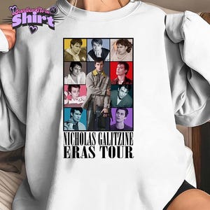 May include: White crew neck t-shirt featuring a grid of nine images of Nicholas Galitzine, with the text "NICHOLAS GALITZINE ERAS TOUR" in a bold font. The images are in various colors, including yellow, pink, and green.