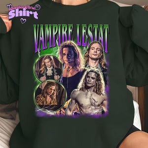 May include: Dark green sweatshirt featuring a graphic of the film "Vampire Lestat". The design includes multiple images of the character, with the title in purple and green. The sweatshirt has a crew neck and long sleeves.