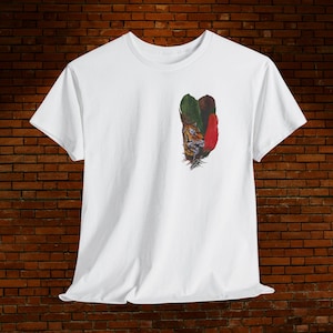 Puede incluir: Camiseta blanca con un diseño colorido de la cara de un tigre y plumas. El diseño incluye plumas verdes, rojas y marrones. La camiseta está hecha de un tejido suave y ligero, ideal para el uso diario.