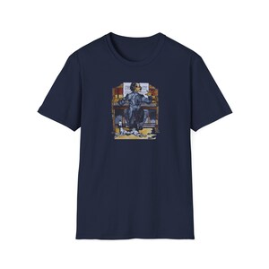May include: A navy blue t-shirt featuring a graphic of a man playing an organ with a dog sitting beside him.