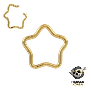 May include: Gold-coloured star-shaped body jewellery. The jewellery is a hoop design with a hinged closure. The star has five rounded points. The image also includes the Pierced Koala logo.